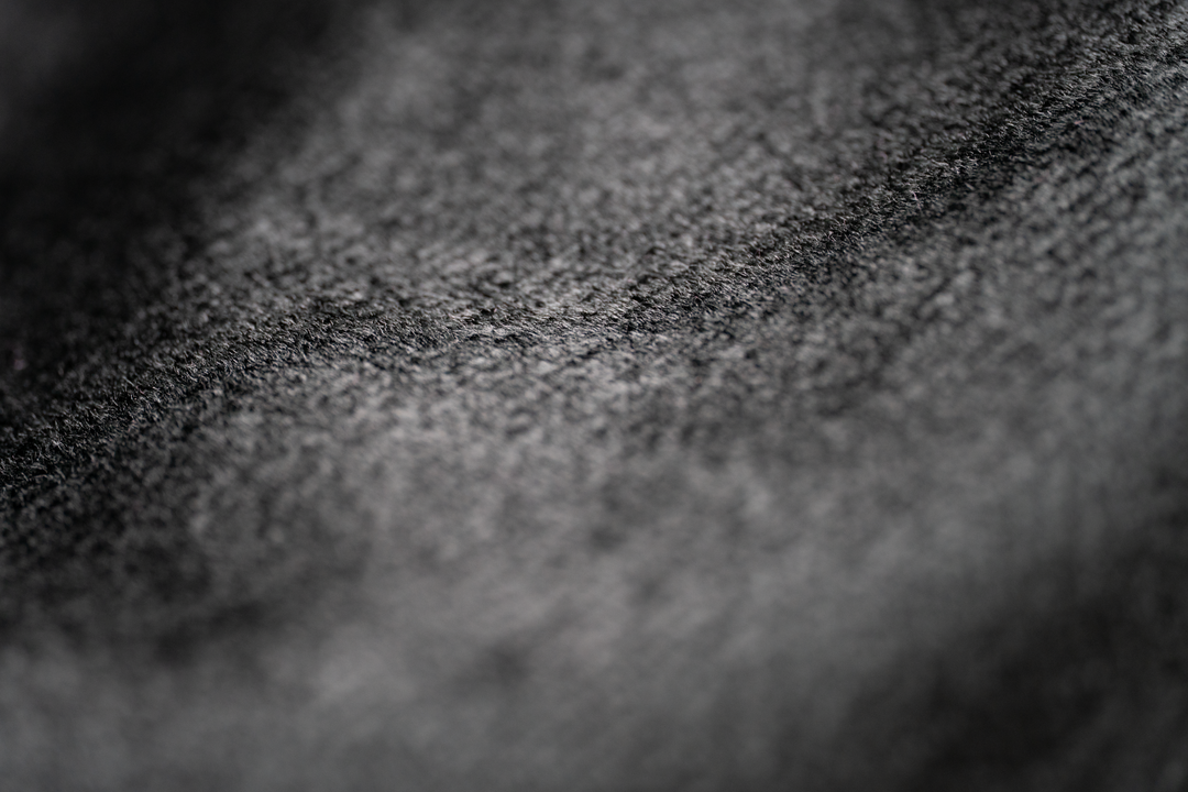 Gros plan d’un textile noir présentant de petites fibres claires en surface