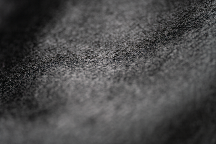 Gros plan d’un textile noir présentant de petites fibres claires en surface