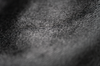 Gros plan sur un textile sombre où des poils d’animaux peuvent rester accrochés